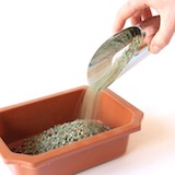 先鋪上一層粗粒、具排水性的介質，例如熔岩石或川砂